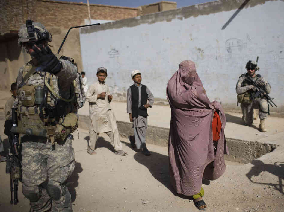 An Afghan woman walks among U.S. soldiers in Kandahar City. An Afghan woman walks among U.S. soldiers in Kandahar City.