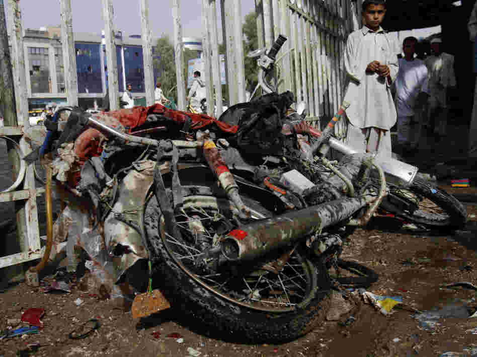 An Afghan boy stands aside a motorbike used by a suicide bomber. An Afghan boy stands aside a motorbike used by a suicide bomber.