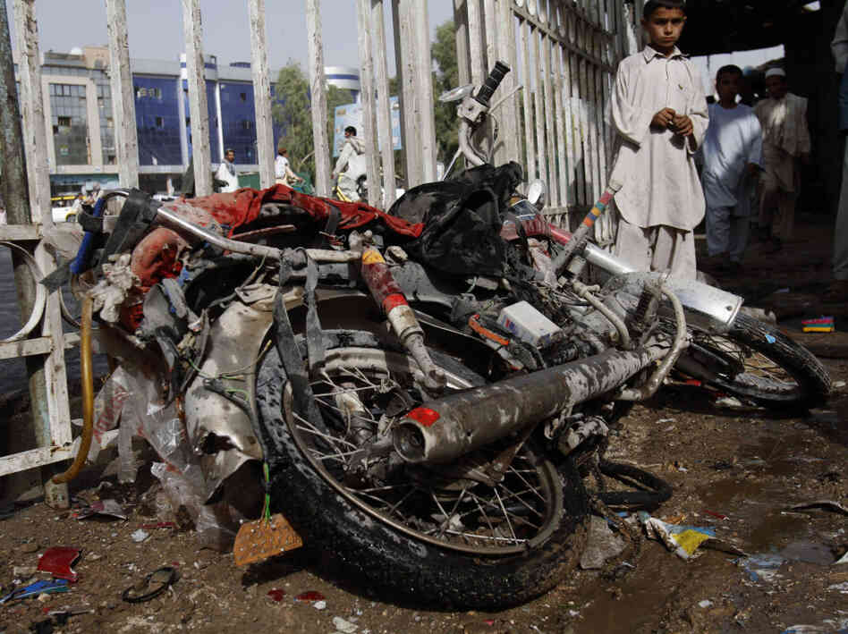 An Afghan boy stands aside a motorbike used by a suicide bomber. An Afghan boy stands aside a motorbike used by a suicide bomber.