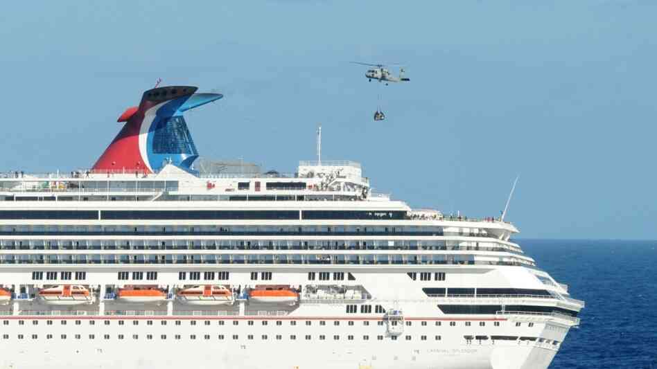 A Navy helicopter delivers pallets of supplies to the Carnival cruise ship Splendor off the coast of A Navy helicopter delivers pallets of supplies to the Carnival cruise ship Splendor off the coast of
