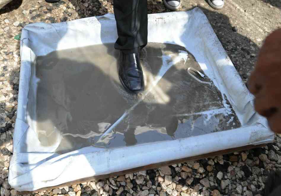 A man steps into a disinfectant wash prior to entering a Port-au-Prince hospital. A man steps into a disinfectant wash prior to entering a Port-au-Prince hospital.