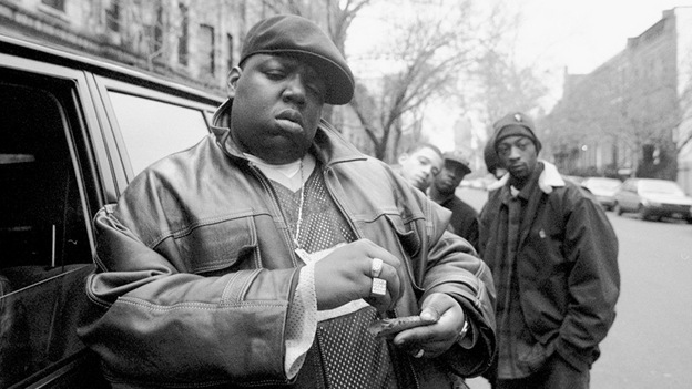 Notorious B.I.G. rolls a cigar outside his mother's house in Brooklyn in 1995. (Getty Images)