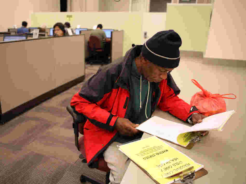 Maurice Jones looks through job listings at a career center in Oakland, Calif. Maurice Jones looks through job listings at a career center in Oakland, Calif.