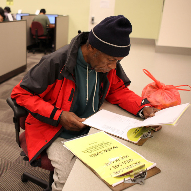 Maurice Jones looks through job listings at a career center in Oakland, Calif.