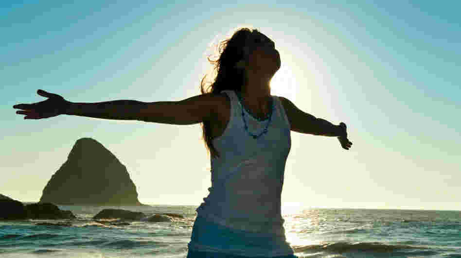 Happy woman stretches out her arms at the beach. Happy woman stretches out her arms at the beach.