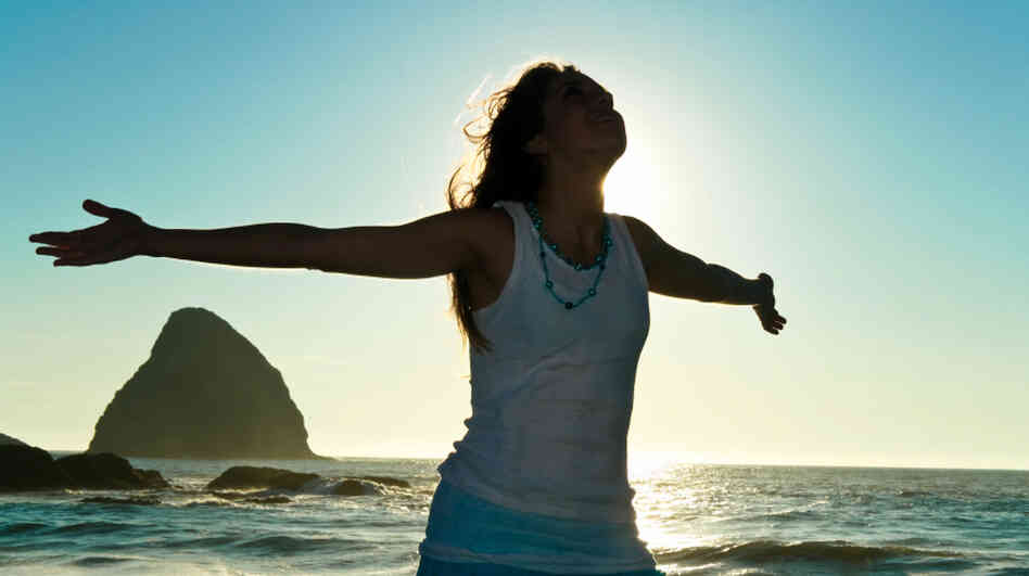 Happy woman stretches out her arms at the beach. Happy woman stretches out her arms at the beach.