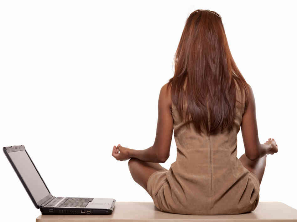 Woman performs yoga next to her open laptop. Woman performs yoga next to her open laptop.
