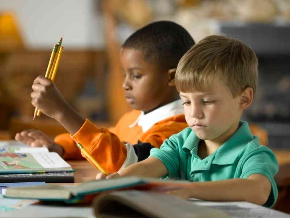 Two boys learn to read in school Two boys learn to read in school