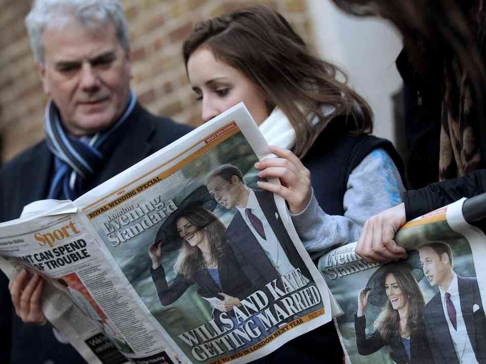 A woman reads a newspaper shortly after Prince William and Kate Middleton announced their eng A woman reads a newspaper shortly after Prince William and Kate Middleton announced their eng