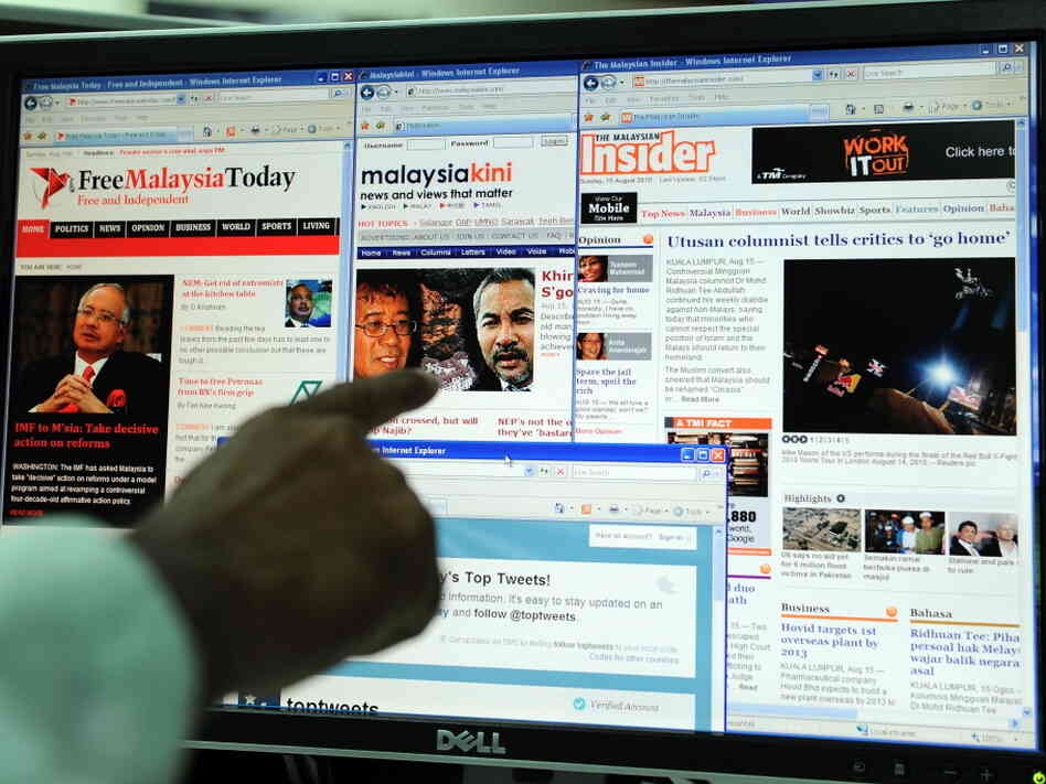 A computer user in Kuala Lumpur points to local news portals on the Internet.