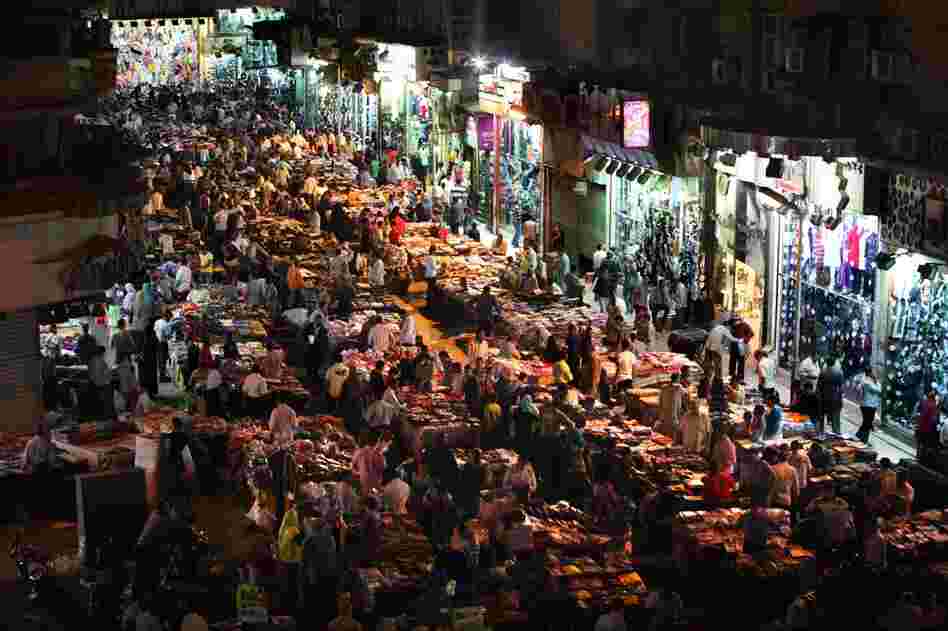 Surrounded by shops, Cairenes buy and sell black market goods in the middle of a street in the Ataba district. The vendors have set up their stalls illegally and do not pay rent, ultilities or taxes.