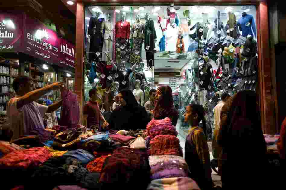 A vendor holds up a shirt for customers in the Ataba market.