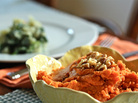 Thanksgiving table set with dishes of greens and sweet potato mash Thanksgiving table set with dishes of greens and sweet potato mash