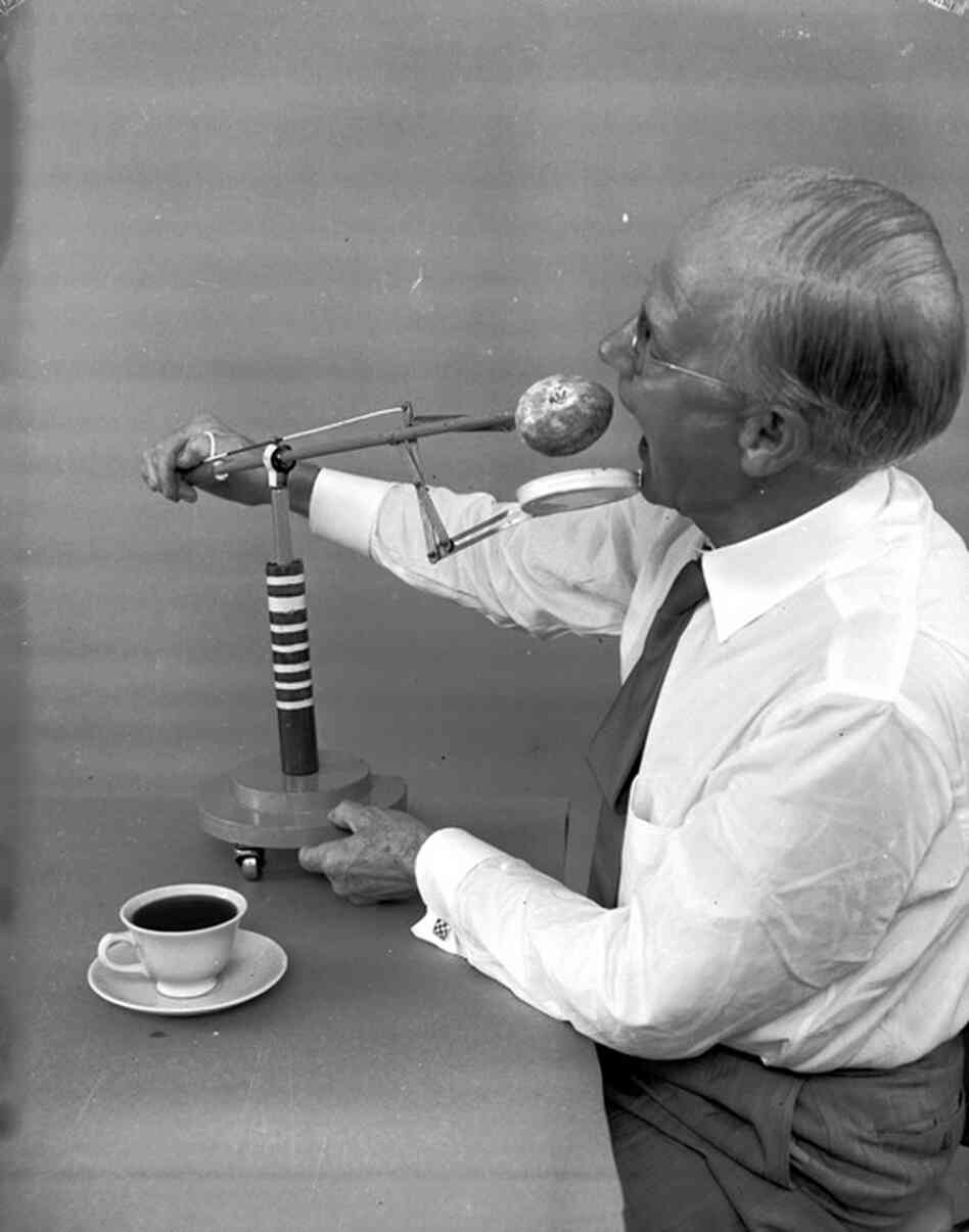 American amateur inventor Russel E. Oakes demonstrates his doughnut dunker, which prevents doughnuts from dripping and wetting the diner's fingers, heaven forbid. 
