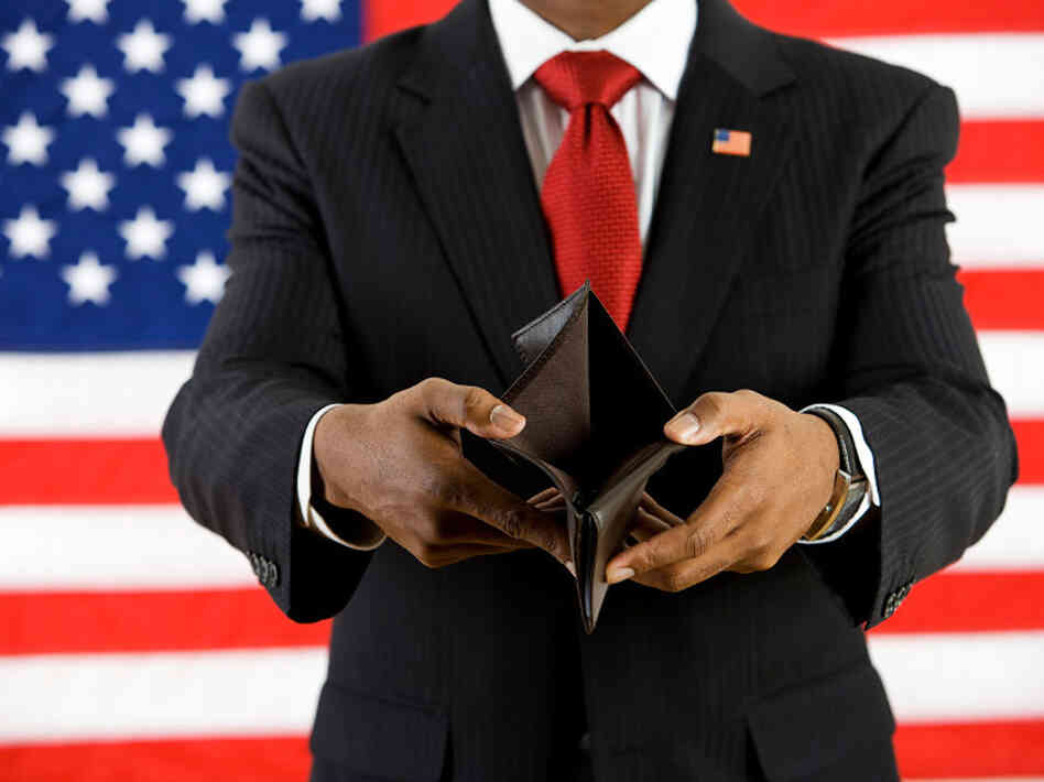 A man representing a lawmaker standing in front of a U.S. flag opens his empty wallet A man representing a lawmaker standing in front of a U.S. flag opens his empty wallet