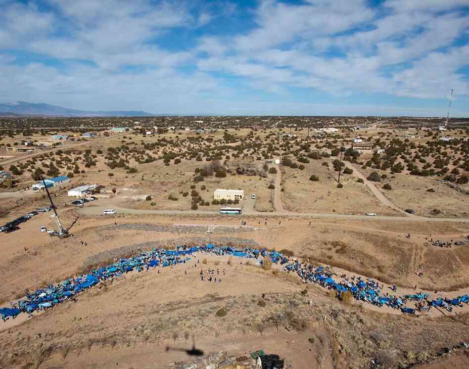 The Santa Fe EARTH event shows how the endangered Santa Fe River could look if there were water running through it. To simulate the appearance of a river, more than 1,000 people held up blue painted pieces of cardboard or tarps."Flash Flood" by Santa Fe Art Institute 