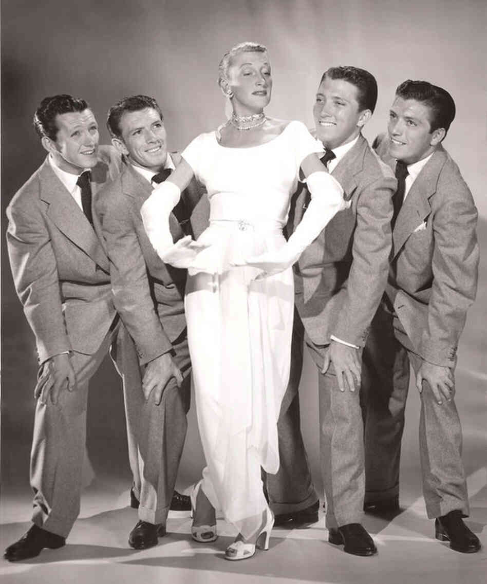 After leaving MGM, Thompson co-created the nightclub act "Kay Thompson and the Williams Brothers." She poses with them here in 1947.