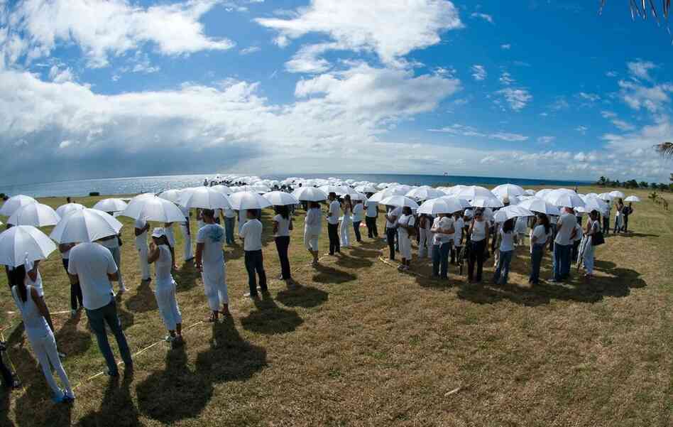 Hundreds of people in white gathered in the Dominican Republic to demonstrate the threat of sea-level rise to an island nation. 