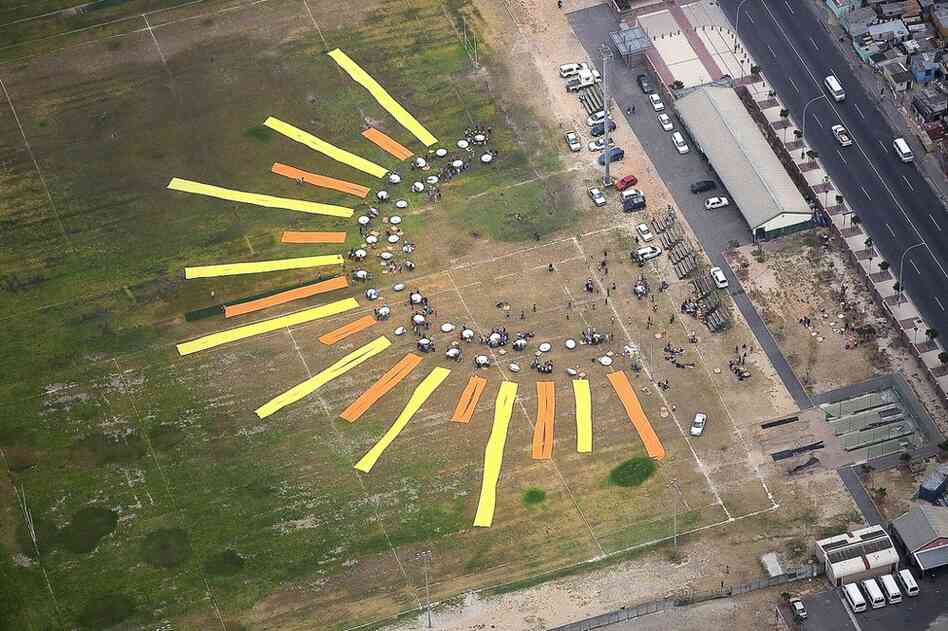 In Cape Town, South Africa, The Canary Project and local citizens created an enormous sun out of 70 high-powered parabolic solar cookers and table cloths. Each cooker lasts for 10 years and requires no fossil fuels, saving money for families while also protecting their health and the environment. 
