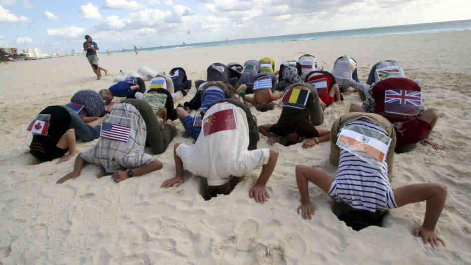 Sierra Club activists bury their heads in sand in Cancun in protest of the U.N. Climate Conference Sierra Club activists bury their heads in sand in Cancun in protest of the U.N. Climate Conference