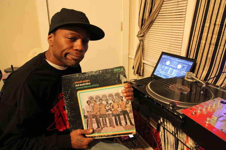 Traxman holding a record of Pharoah Sanders.