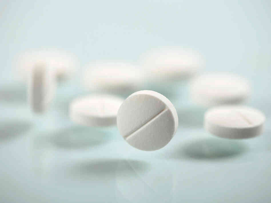 Aspirin tablets rest on a sheet of glass. Aspirin tablets rest on a sheet of glass.