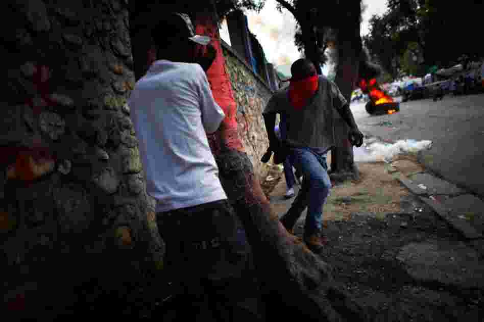 Supporters of Michel Martelly run from tear gas being fired by UN soldiers.