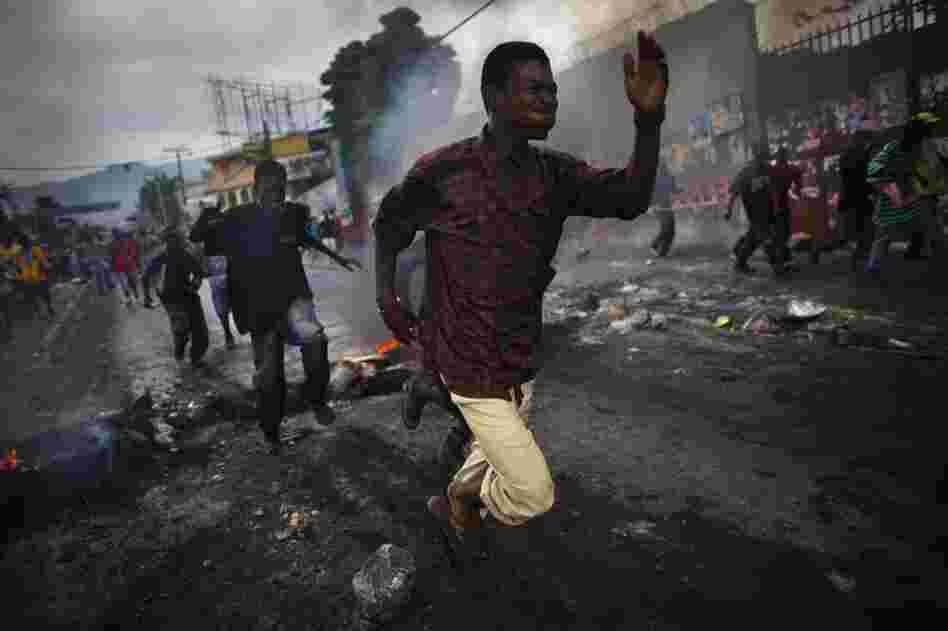 Supporters of Michel Martelly run from tear gas fired by U.N. soldiers.