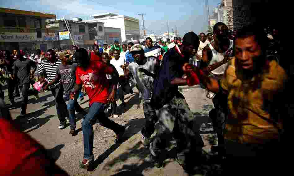 Martelly supporters run from tear gas fired from an election office in Port-au Prince on Wednesday. On Tuesday night, demonstrators set up flaming barricades near a restaurant in Petionville, a suburb of the capital where the tallies were announced, and threw rocks at passersby.