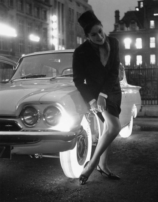 What ever happened to illuminated tires? And more importantly, what compelled this woman to adjust her stockings awkwardly in front of an illuminated tire? 