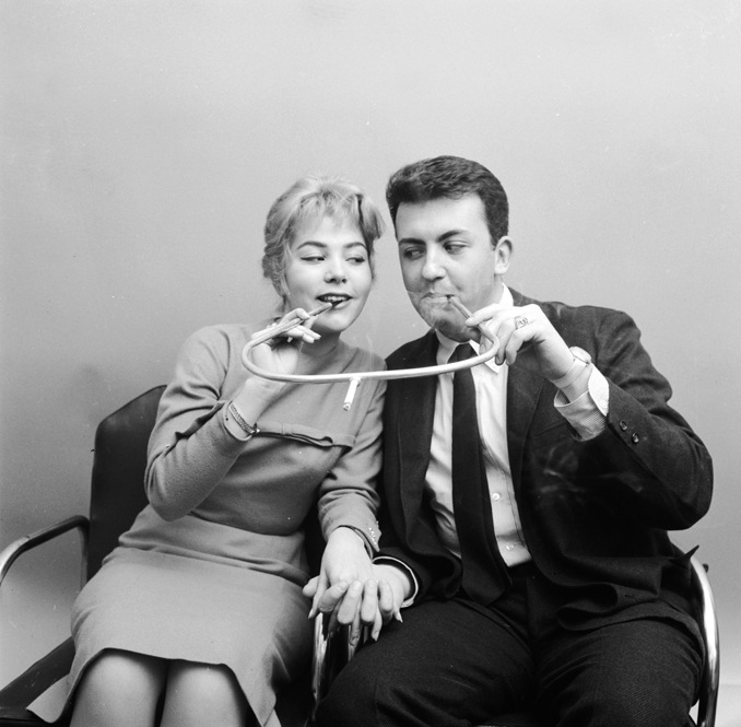 Daisy, Daisy, give me your answer, do. Would you like to smoke a cigarette in this romantic holder built for two?Image circa 1955 