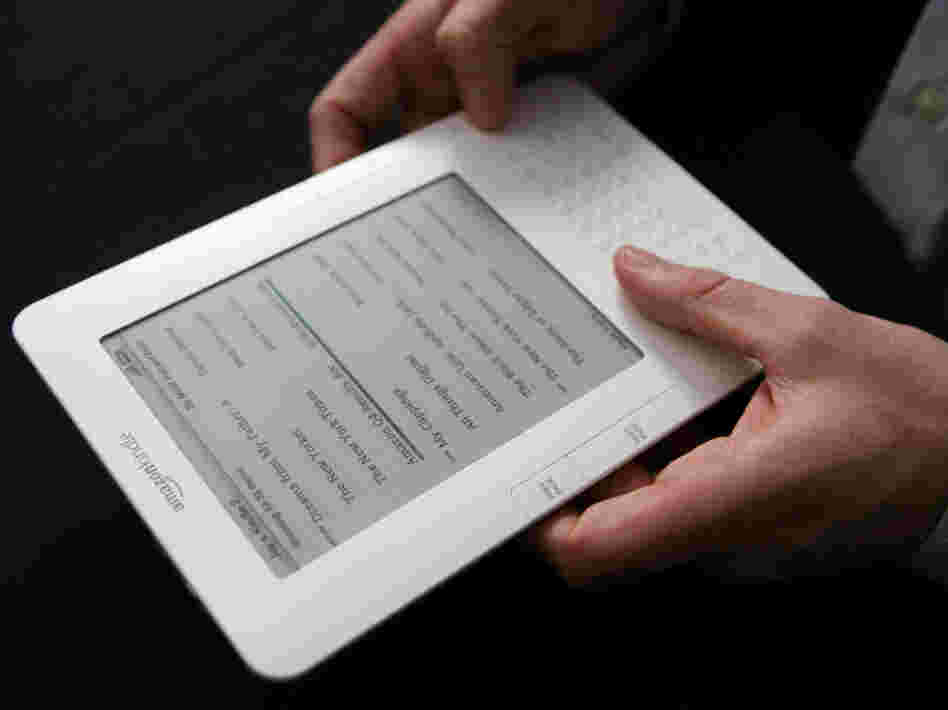 A Kindle e-reader in someone's hands. A Kindle e-reader in someone's hands.