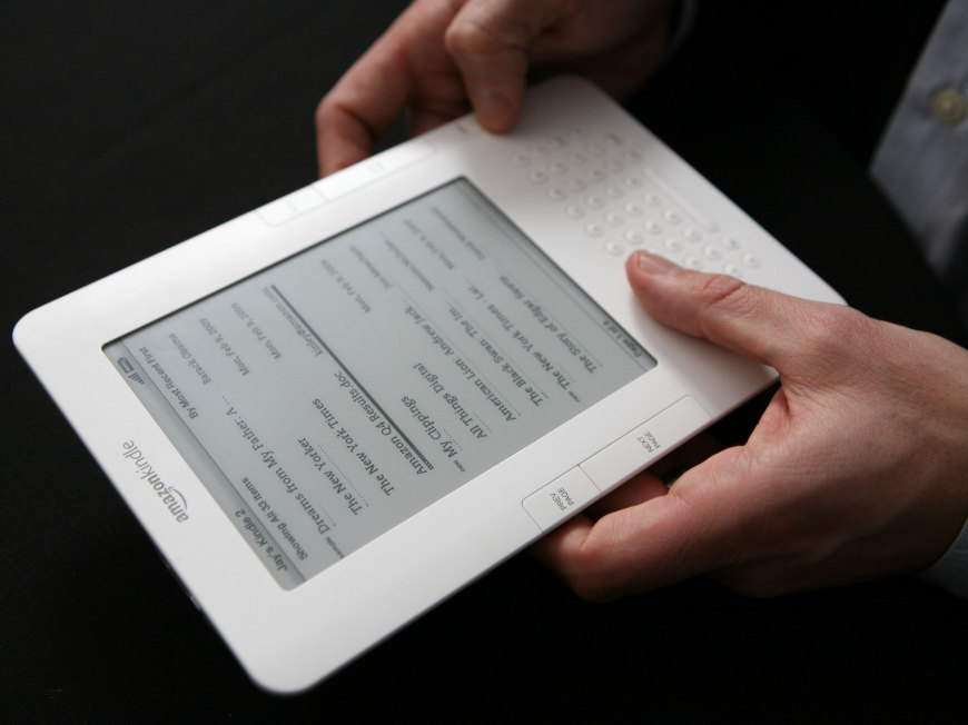 A Kindle e-reader in someone's hands.