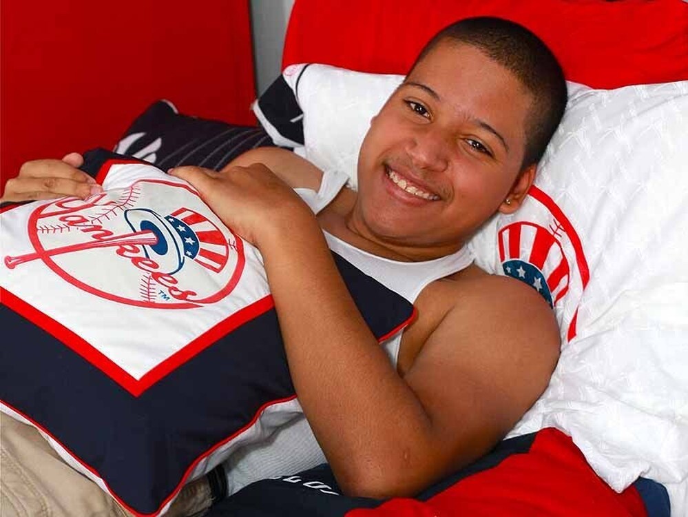 Eighteen-year-old Jesus German relaxes in his newly-transformed, Yankees-themed room in the Bronx. Blissful Bedrooms also arranged for German, who has spina bifida, to go to a Yankees game and meet his hero, Alex Rodriguez.