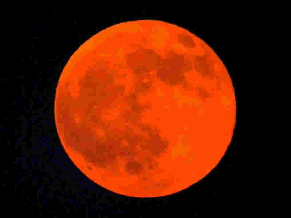 The moon appears red during a lunar eclipse in the Qatari capital of Doha, 28 August 2007. It's going to happen again tonight, and be visible across North America.