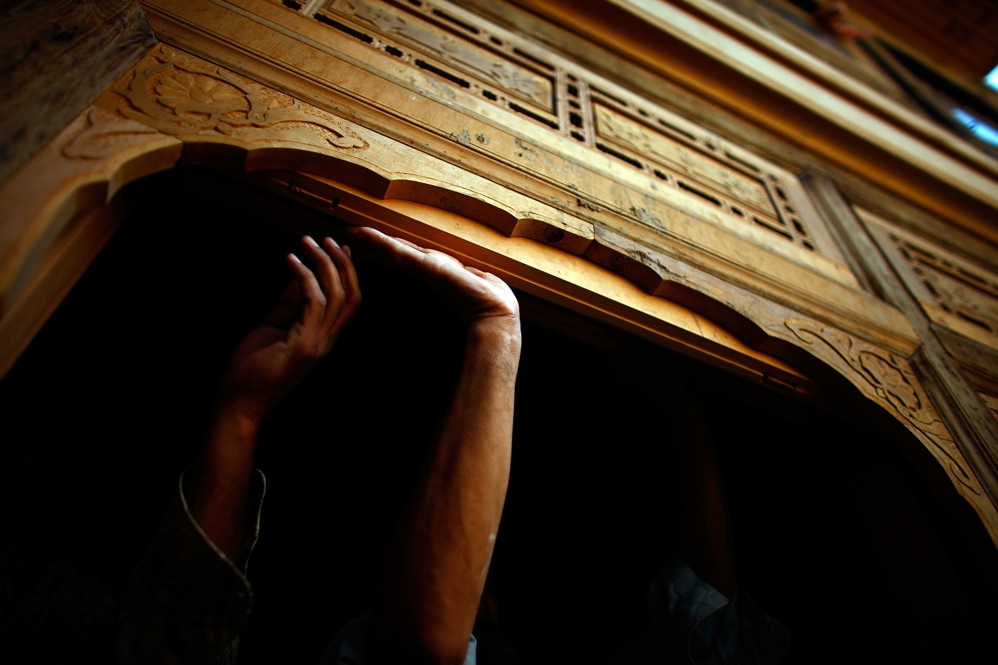 Craftsmen hand cut and carve all of the lumber that will be used for door and window frames in the district.