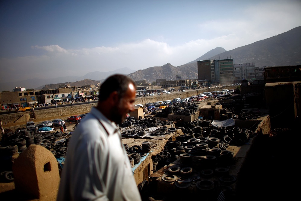 A man walks on the roof of a restored building in the Old City district. A sea of used tires stretches from the ancient quarter to the Kabul River. Many of the mud-walled houses in Murad Khane were buried under trash after 30 years of war and neglect.