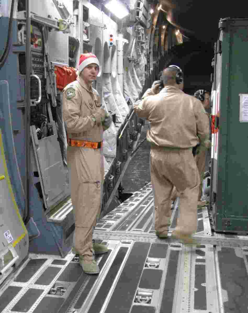 Air Force Capt. Blake Putnam, left, helps convert the massive hold of the C-17 plane from carrying cargo into a flying hospital.
