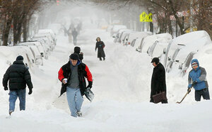People walk through the snow in Manhattan's East Village in New York City. The tail end of a powerful storm across the Northeast snarled plans for millions of holiday travelers Monday, forcing airport closures and crippling road and rail traffic. The New York area was especially hard hit.