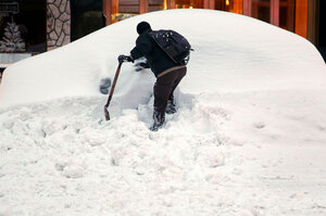 John Elliot of New York tries to dig out his rental car on a Manhattan street thanks in part to a good Samaritan who let him use a shovel.