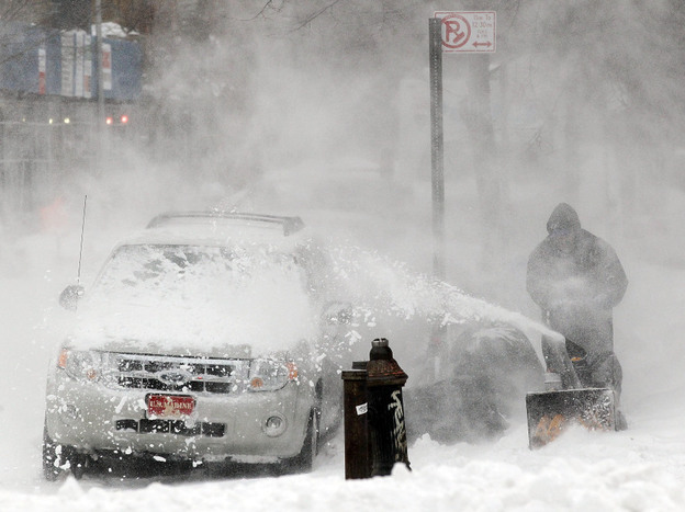 A man clears snow in Manhattan's East Village earlier today.