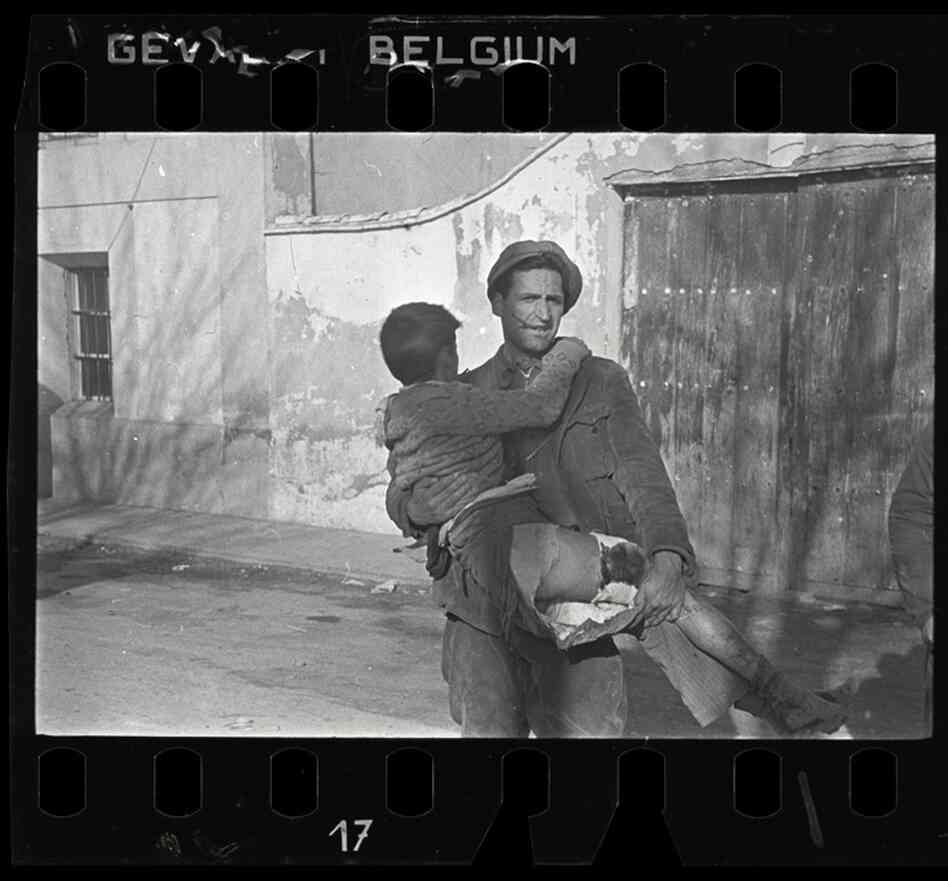 Man carrying a wounded boy, Teruel, Spain, late Dec. 1937 