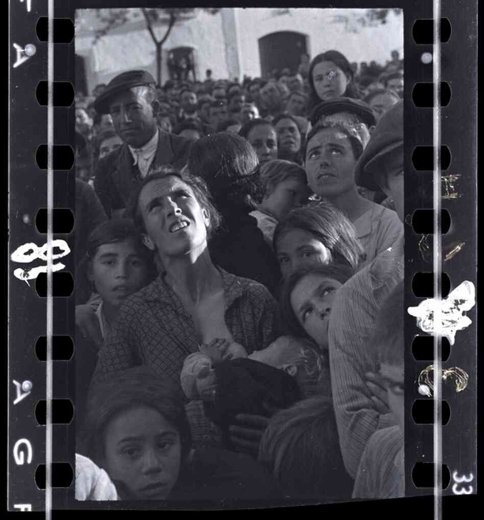 Mother nursing a baby while listening to political speech, near Badajoz, Extremadura, Spain, late April - early May 1936 )