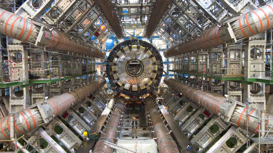 One of the goals of the ATLAS detector at the Large Hadron Collider is to search for the Higgs boson, a particle that scientists say gives everything in the universe mass. For scale, note the workers toward the bottom of the image. One of the goals of the ATLAS detector at the Large Hadron Collider is to search for the Higgs boson, a particle that scientists say gives everything in the universe mass. For scale, note the workers toward the bottom of the image.