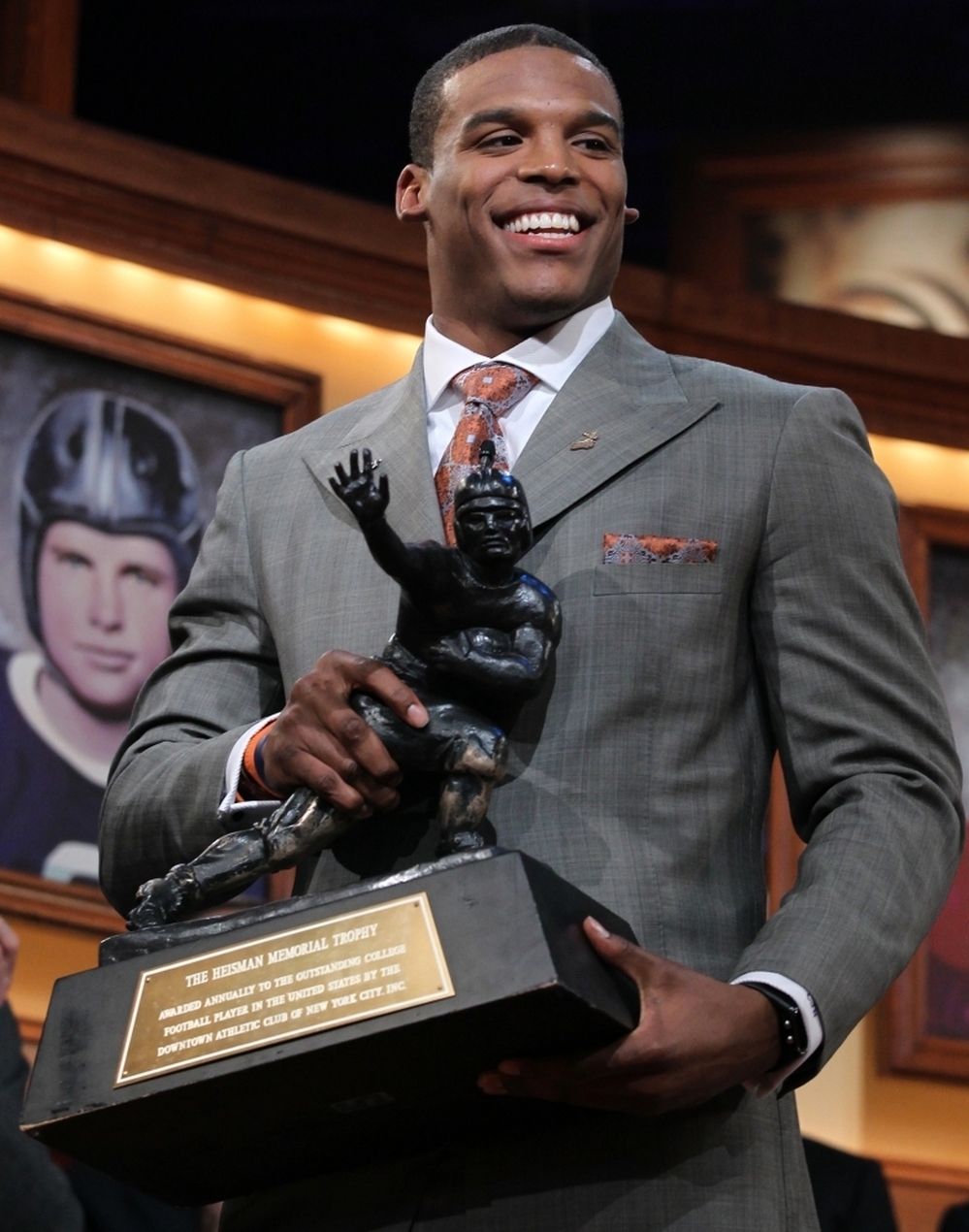 Auburn quarterback Cam Newton picks up the Heisman Trophy after his acceptance speech. Newton's father has been accused of trying to solicit Mississippi State for money in exchange for his son's athletic service.
