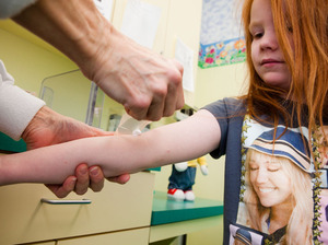 A nurse applies a numbing cream to Katie's arm so she can draw blood to check her lead level. Katie's lead level has gone down since her last visit but, as she goes through a growth spurt, her bones release more lead into her blood. A nurse applies a numbing cream to Katie's arm so she can draw blood to check her lead level. Katie's lead level has gone down since her last visit but, as she goes through a growth spurt, her bones release more lead into her blood.