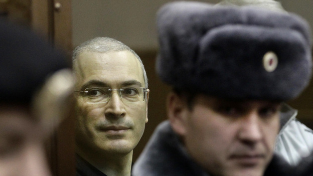 Mikhail Khodorkovsky, center, looks from behind a glass enclosure at a court room in Moscow,  Russia, Thursday, Dec. 30, 2010.