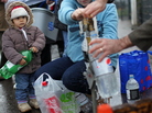 A young child held an empty bottle as people queued to recieve water from a tap in Belfast on Wednesday. A young child held an empty bottle as people queued to recieve water from a tap in Belfast on Wednesday.