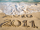An ocean wave washes away the year 2010 written in beach sand. An ocean wave washes away the year 2010 written in beach sand.
