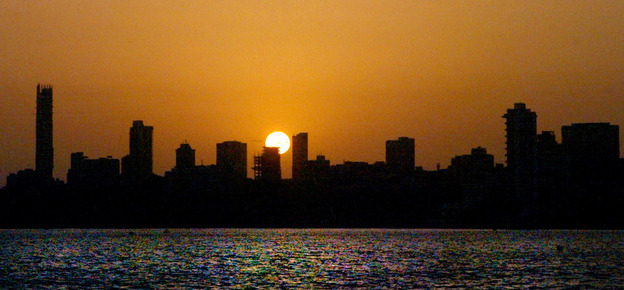 The sun sets over a stretch of the skyline in Mumbai, India.